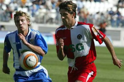 El centrocampista del Getafe, Veljko Paunovic (drcha.), y el defensa del Málaga Alexis Ruano luchan por el balón.