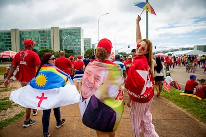 Tres entusiastas de Lula da Silva caminan hacia el Palacio de Planalto para poder ver al líder del Partido de los Trabajadores después de juramentar como presidente de la nación.