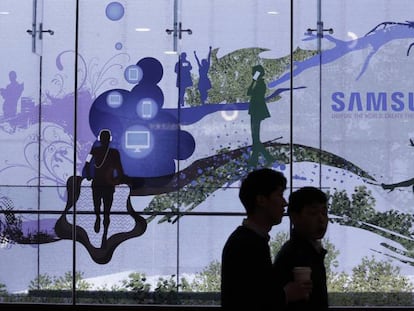 Dos personas pasean en Seúl ante una tienda de Samsung. 