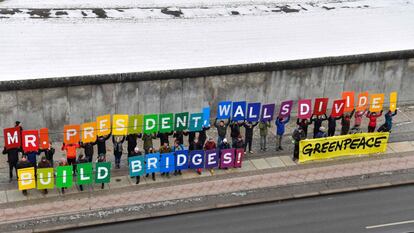 Un grupo de activistas de Greenpeace muestran pancartas con el mensaje "Sr. Presidente, los muros dividen. Construye puentes!" en el muro de Berlín (Alemania).