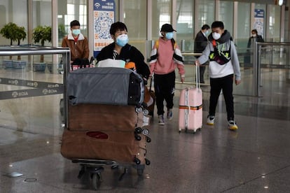 Passengers wear face masks as a preventive measure against the COVID-19 coronavirus as they arrive from an international flight at Beijing Capital Airport in Beijing on March 11, 2020. - China reported an increase in imported coronavirus cases on March 11, fuelling concerns that infections from overseas could undermine progress in halting the spread of the virus. (Photo by GREG BAKER / AFP)