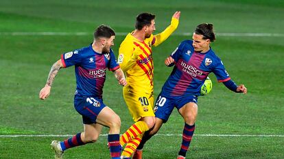 Messi, ante Javi Galán y Seoane en el duelo del Barcelona ante el Huesca.