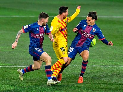 Messi, ante Javi Galán y Seoane en el duelo del Barcelona ante el Huesca.
