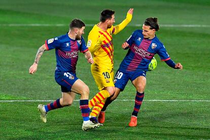 Messi, ante Javi Galán y Seoane en el duelo del Barcelona ante el Huesca.