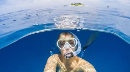 Una mujer se sumerge debajo del agua del mar mediante la técnica del 'snorkel'.