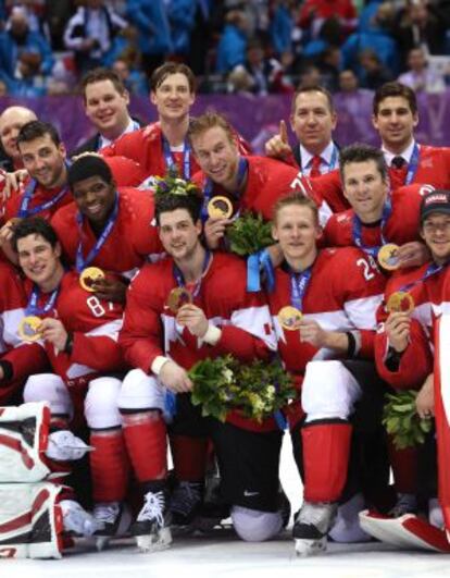El equipo masculino de hockey canadiense posa con la medalla de oro