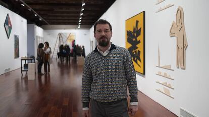 Miki Leal, este jueves en Sevilla en la muestra 'El abrazo'. A la derecha, las obras de Palazuelo (lienzo) y de Pereñiguez.
