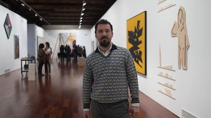 Miki Leal, este jueves en Sevilla en la muestra 'El abrazo'. A la derecha, las obras de Palazuelo (lienzo) y de Pereñiguez.