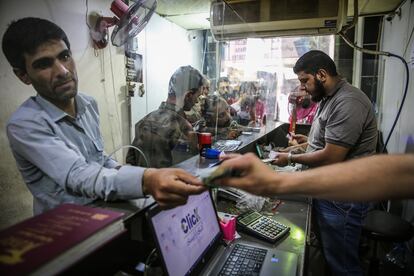Unos sirios cambian la moneda local por liras turcas o dólares en una casa de cambio informal en la insurrecta provincia de Idlib.