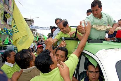 Rafael Correa (dcha.), candidato a la presidencia de Ecuador por el movimiento izquierdista Alianza País, saluda a sus simpatizantes este miércoles 11 de octubre, durante un recorrido de campaña por el norte de la ciudad de Guayaquil.