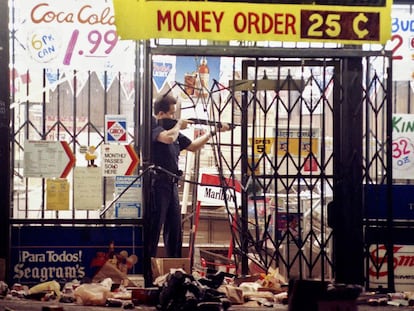 Un policía encañona a un ladrón en una tienda de alimentación de Los Ángeles, el 30 de abril de 1992, la segunda noche de disturbios.