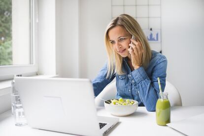 Mujer come fruta mientras teletrabaja