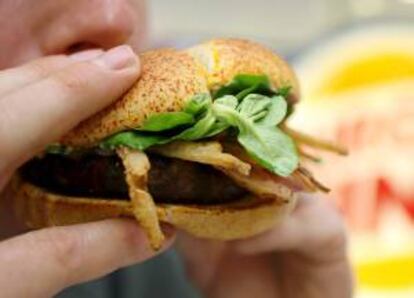 Un hombre prueba una hamburguesa. EFE/Archivo