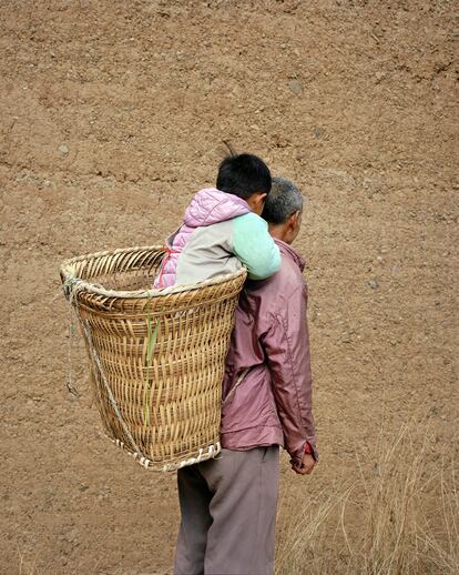 Abuelo y nieto en Yunnan. Son muchos los niños que se quedan en el campo cuando sus padres marchan a vivir a la ciudad para que cuiden de sus abuelos  quienes los mantienen a lo largo de siete años. Solo ven sus padres una vez al año,2019.