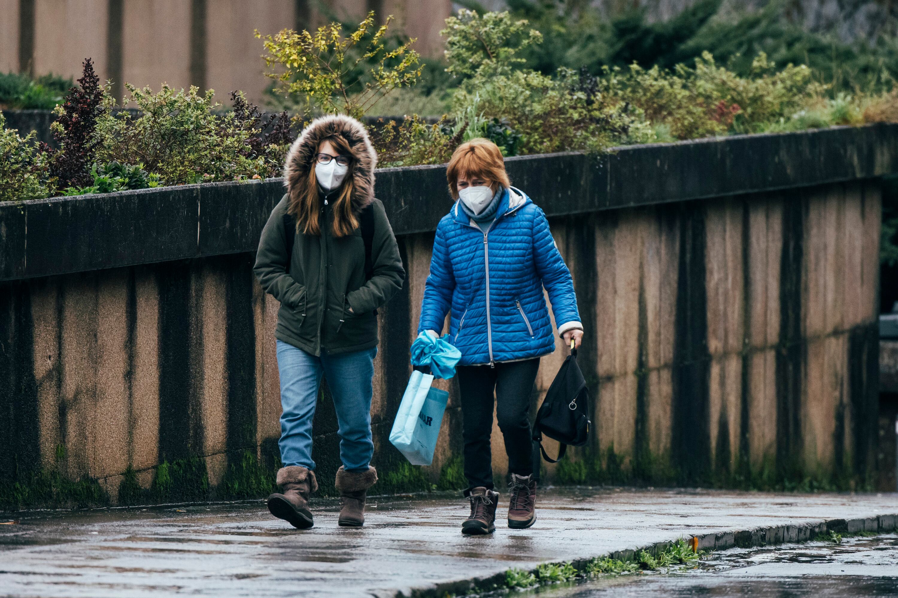 Dos personas salen de un centro de salud, donde se han impuesto nuevamente el uso obligatorio de mascarillas, este jueves en Santiago de Compostela.