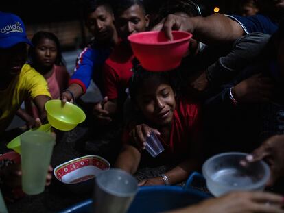 Indígenas venezolanos de la etnia Warao se congregan para distribuir alimentos antes de una sesión de cine el 6 de abril de 2019 en Pacaraima, Brasil.