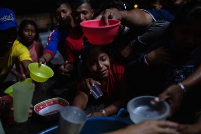 Indígenas venezolanos de la etnia Warao se congregan para distribuir alimentos antes de una sesión de cine el 6 de abril de 2019 en Pacaraima, Brasil.