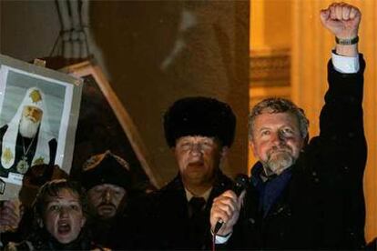 Los lderes de la oposicin, Alexandr Milinkevich (pu?o en alto) y Alexandr Kozulin (segundo por la derecha), saludan a sus partidarios anoche en Minsk.