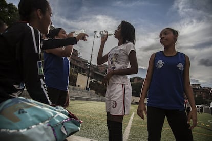 Un grupo de jugadoras se refresca durante un descanso en el entrenamiento. "La cancha tiene el potencial de borrar los estigmas sociales, por lo menos por un rato. Permite establecer puentes. Ni siquiera hace falta hablar el mismo idioma, basta con saberse las reglas", explica Manuel Llorens, psicólogo y miembro de la junta directiva de Pasión Petare.