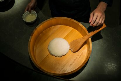 

Tadayoshi Motoa mezcla el arroz con el vinagre en un 'hangiri' (palangana de madera).