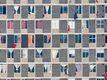 Edifício no centro de Bogotá onde janelas exibem panos vermelhos como pedido de ajuda.