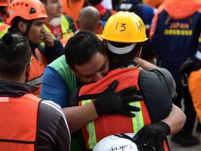 Miembros de un grupo de rescate se abrazan tras sonar la alerta sísmica este sábado en Ciudad de México.