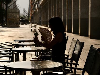 Una mujer se abanica en una terraza en la Gran Vía de Logroño, el sábado.