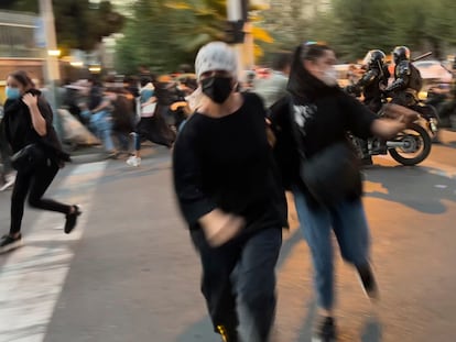 Dos mujeres huyen de la policía en una manifestación por la muerte de Mahsa Yina Amina, el 19 de septiembre de 2022 en Teherán.