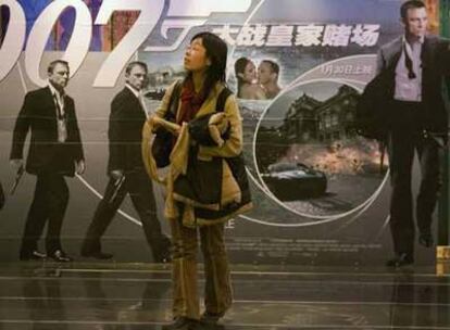 Una mujer china pasa por delante de uno de los carteles promocionales de la película <i>Casino Royal</i>. Por primera vez en 45 años, una de las películas de la saga de James Bond ha pasado la censura en este país y podrá ser exhibida en los cines. El estreno en Pekín, con la asistencia de los actores, promete ser uno de los eventos más 'glamourosos' en la historia de China.
