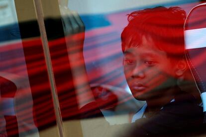 Una pariente de un pasajero que murió en el accidente de Lion Air JT-610 en el mar de Java, mira por una ventana de un autobús después de asistir a la conmemoración de un año del accidente en Yakarta (Indonesia).