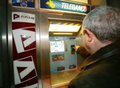 Un hombre retira dinero en un cajero automático.
