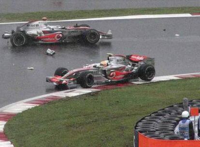 Lewis Hamilton pasa por delante de Fernando Alonso tras sufrir el español un accidente.