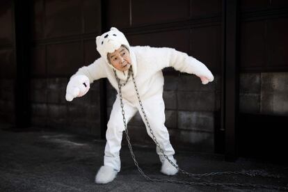 Kimiko Nishimoto, disfrazada de perro, posa como si estuviera encadenada a un poste.