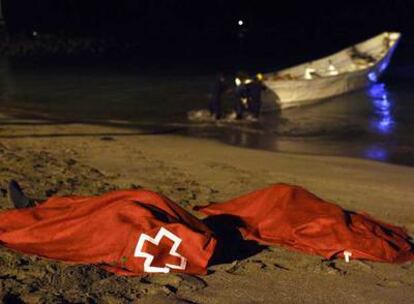 Los dos cadáveres hallados en una de las pateras, cubiertos por mantas tras ser desembarcados en la playa.