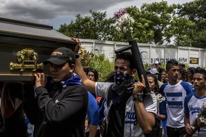 Un grupo de jóvenes carga el ataúd de Gerald Vásquez camino al cementerio.