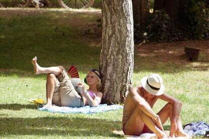 Dos personas descansan en el madrileño parque de El Retiro.