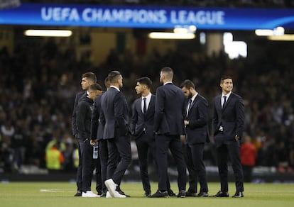 Os jogadores do Real Madrid inspecionam a grama do estádio de Cardiff antes da final.