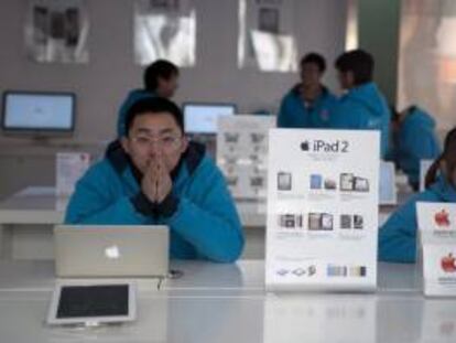 Vendedores esperan la llegada de clientes en una tienda Apple en Qingdao, en la provincia china de Shandong. EFE/Archivo