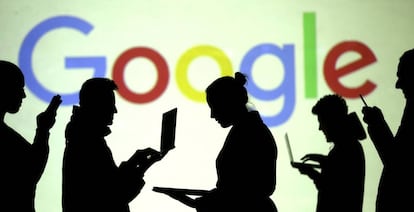 Silueta de usuarios de ordenadores y de móviles frente al logo de Google. 