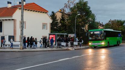 Decenas de personas esperan su turno para subir a unos de los autobuses de servicios mínimos, este lunes en Madrid. 