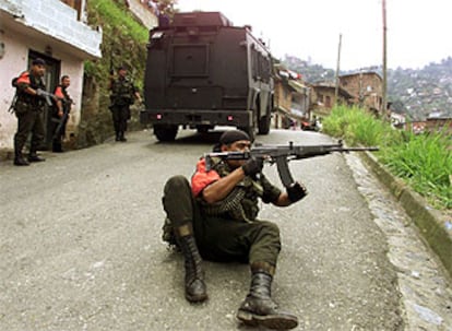 Un policía colombiano se dispone a disparar su arma en la zona de Medellín denominada Comuna 13 durante los enfrentamientos con la guerrilla.