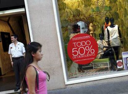 Una mujer pasa ante un escaparate durante la campaña de rebajas.