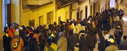 Inmigrantes ante el comedor de Cáritas de Úbeda.