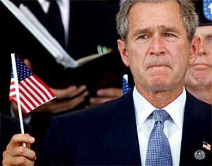 El presidente George W. Bush, con lágrimas en los ojos, ondea una bandera estadounidense en la ceremonia de homenaje a las víctimas del Pentágono.