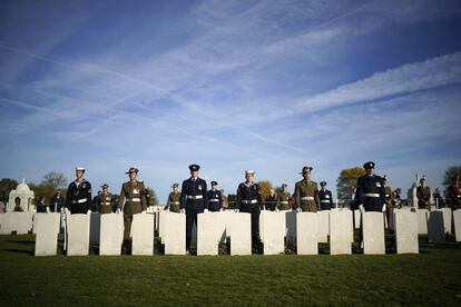 El personal de servicio de las fuerzas armadas británicas y australianas participa en una guardia de honor mientras los cuerpos de tres soldados desconocidos de la Primera Guerra Mundial descansan en el cementerio militar de Tyne Cot. 