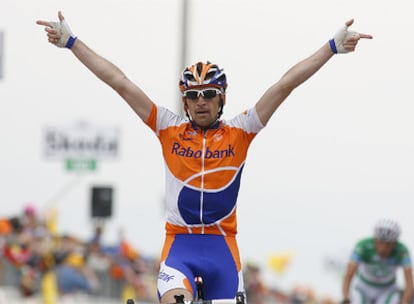 Menchov levanta los brazos celebrando la victoria en Alpe di Siusi, con el italiano Di Luca al fondo a la derecha.