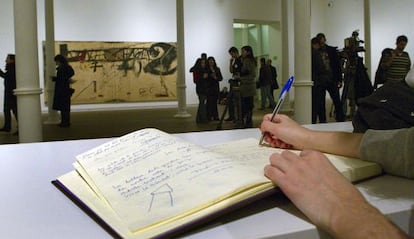 Una persona firma en el libro de condolencia situado en la fundación Tàpies de Barcelona.