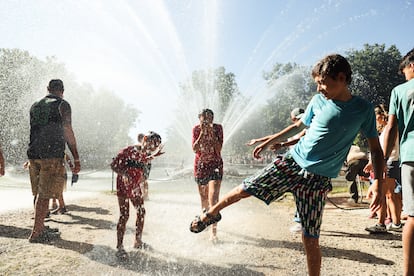 Unos chavales juegan con el agua en la Fuente del Canastillo, durante el encendido. 