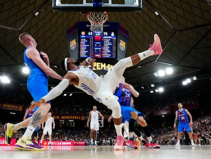 El ala-pívot del Real Madrid Guerschon Yabusele (c) lucha con el letón Rolands Smits (i), del Barça, durante el primer partido de la final de la Liga ACB, este lunes.