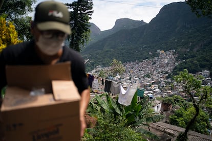 Un voluntario carga una caja de jabón y detergente en Río de Janeiro, el pasado martes.